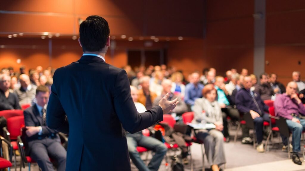 a man standing talking to people showing the concept of how to master public speaking 